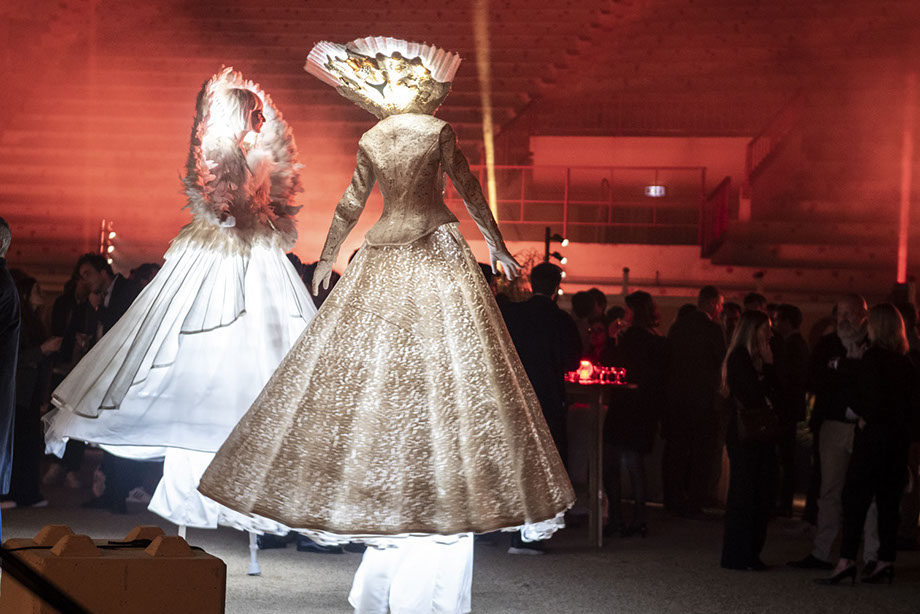échassiers en déambulation sous forme d’animation ou de parade de rue. Artistes en costumes blancs et lumineux dansant sur échasses. Animation